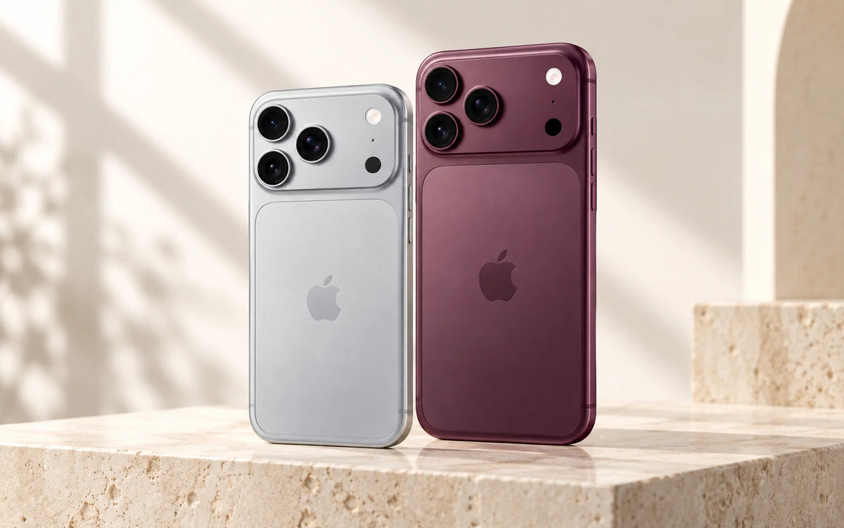 Concept illustration comparing smaller silver and larger burgundy iPhone Pro designs on a stone surface.