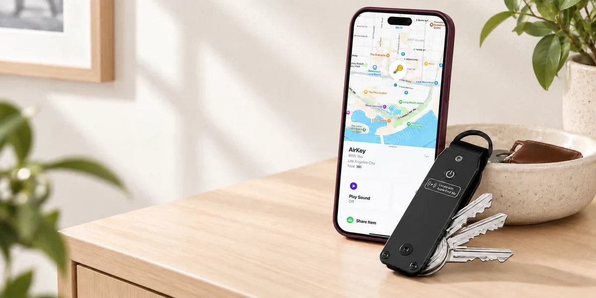 Black key organizer beside a phone showing the supplied tracking screen.