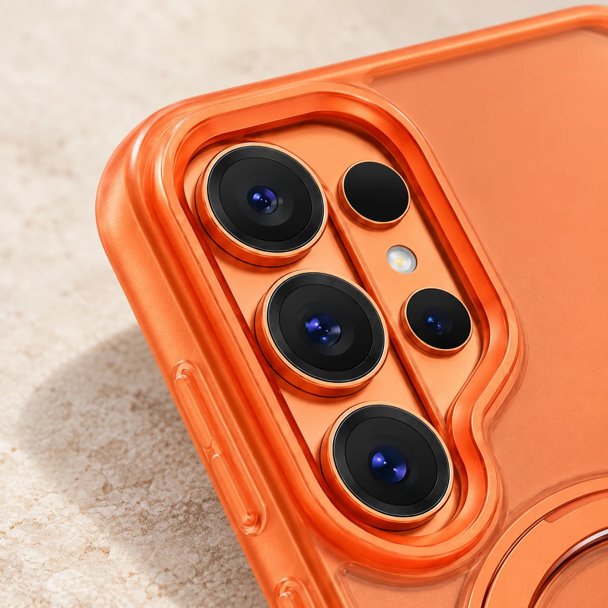 Close-up of the orange case edge around three vertically arranged camera lenses.