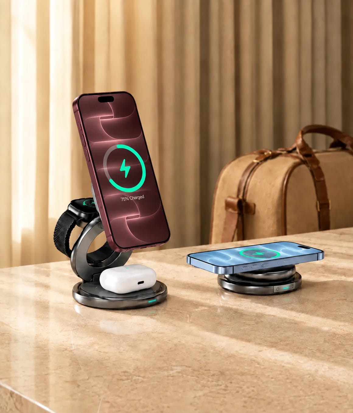 Burgundy and Glacier iPhones charging on foldable wireless chargers beside a travel bag.