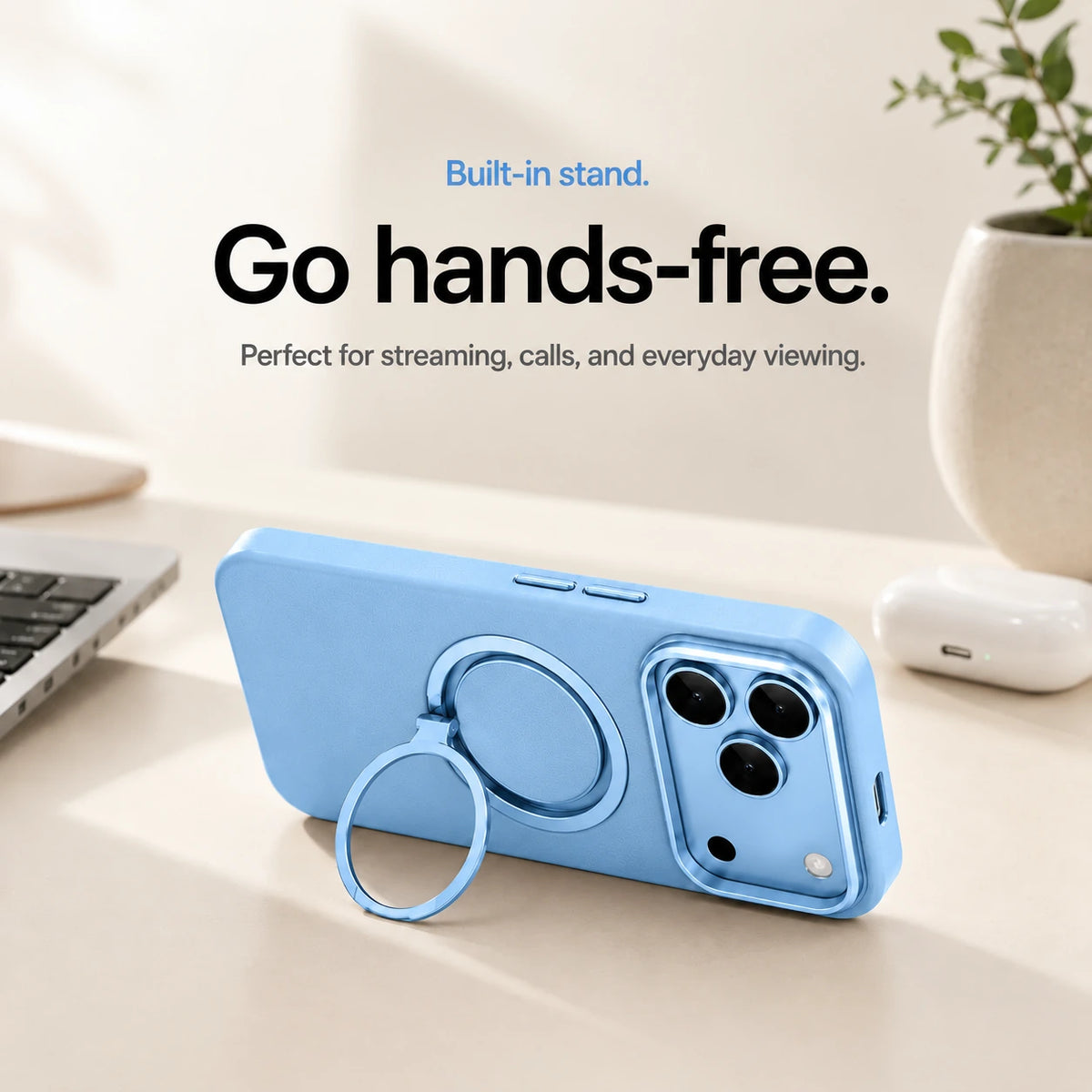 Glacier leather phone case propped horizontally on its ring stand beside a laptop #color_Glacier