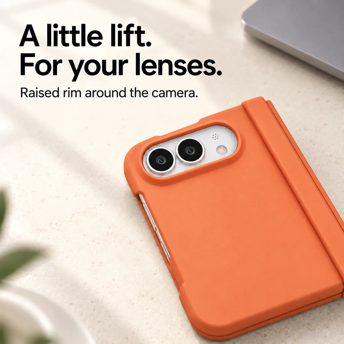 Close-up of the raised Orange camera rim on a matte iPhone Ultra case resting on a light desk. #color_Sunset Orange
