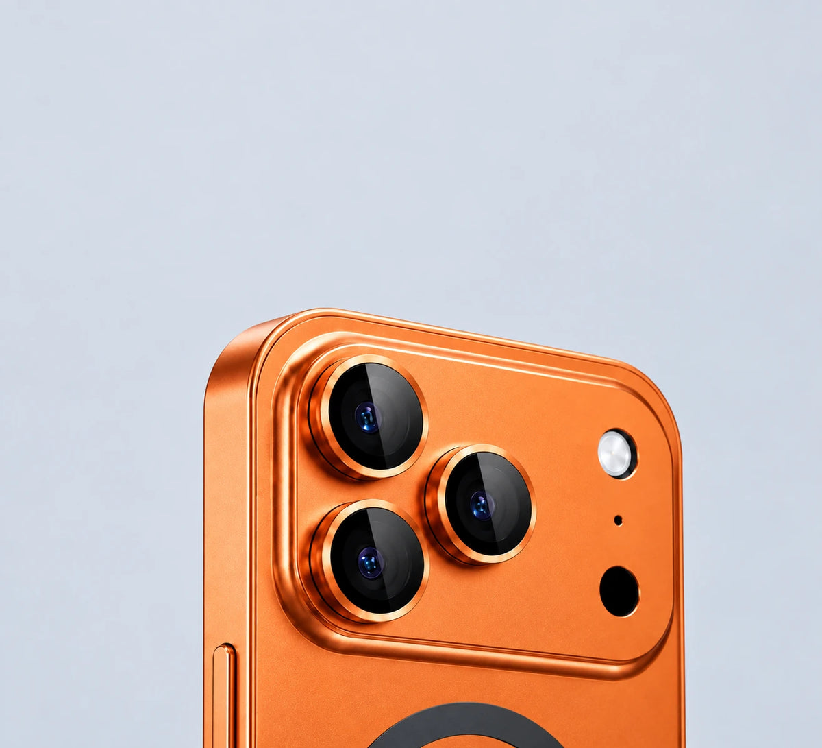 Close view of three glass-covered camera lenses surrounded by raised orange metal rings.
