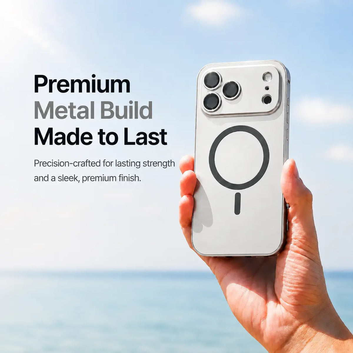Silver metal magnetic phone case held upright beside the sea with a material feature caption #color_Titanium Silver