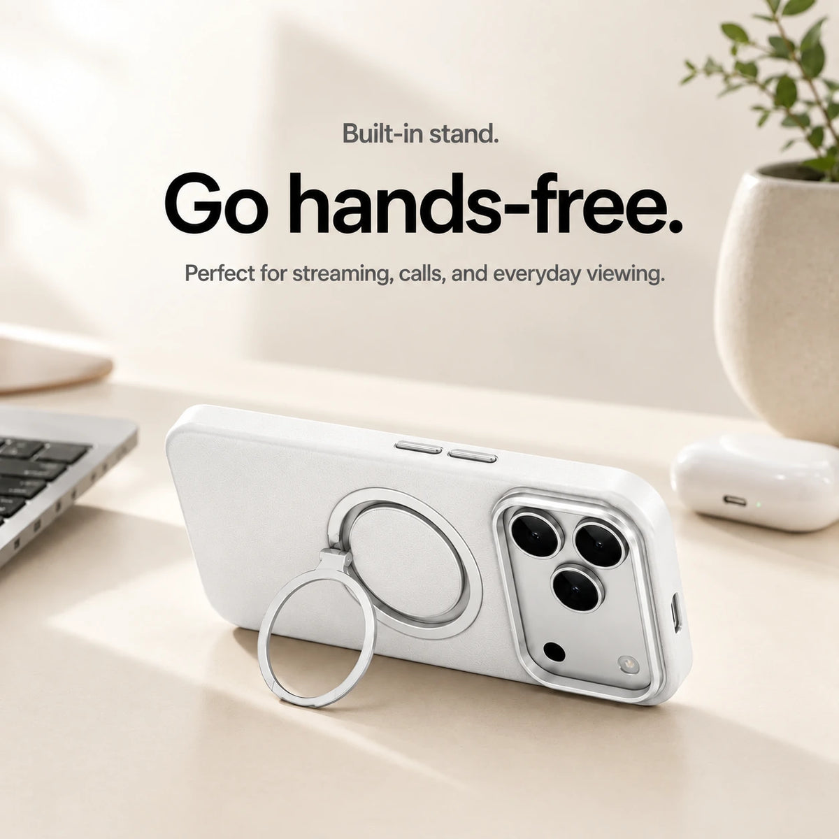 White leather phone case propped horizontally on its ring stand beside a laptop #color_Polar White